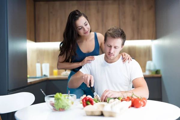 Jong paar koken ontbijt in de keuken samen vrouw knuffelen haar geliefde man familie tradities — Stockfoto