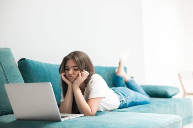 Güzel genç bir kadın dizüstü bilgisayarında konuşurken üzgün görünüyor.