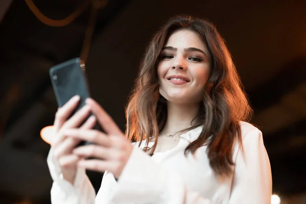 Νέα όμορφη γυναίκα σε λευκό κομψό σακάκι έλεγχο smartphone της αναζητούν ικανοποιημένη σύγχρονη επιχειρηματίας απομονωμένο υπόβαθρο — Φωτογραφία Αρχείου