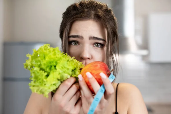 Jovem mulher apto com centímetro de pescoço redondo segurando salada verde e dietologia maçã e nutrição — Fotografia de Stock