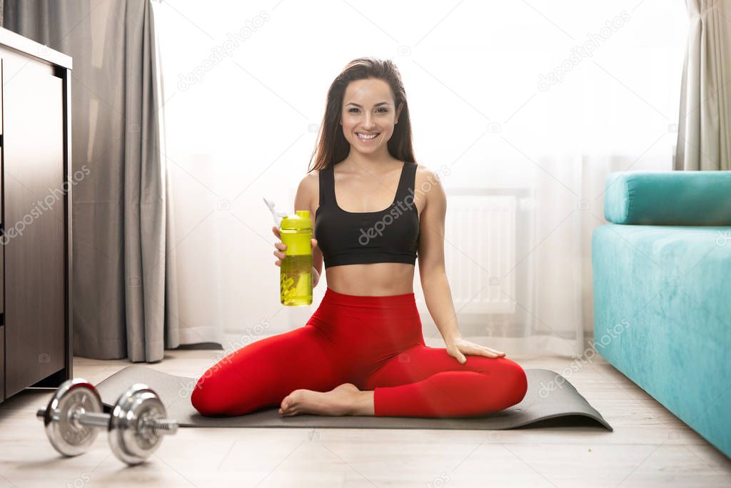 young fit woman in sportwear doing everyday morning warm up exercises on the floor at home, sportive lifestyle