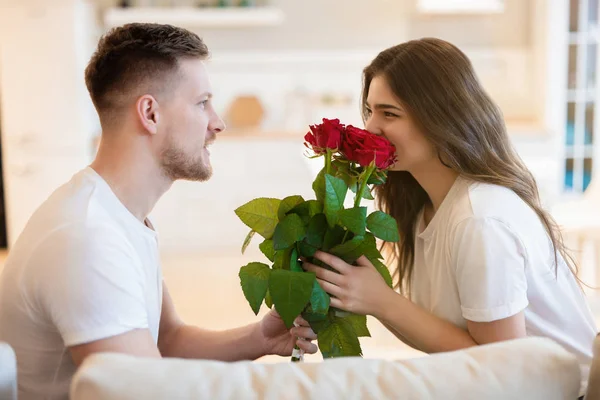 Stilig man överraskar sin vackra fru med rosor på alla hjärtans dag, glad romantisk årsdag — Stockfoto