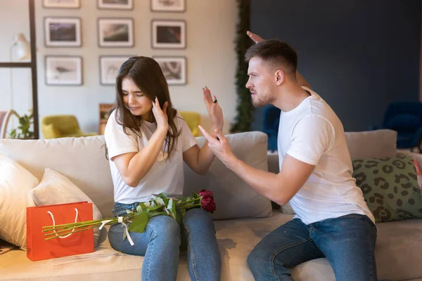 Jong stel mooi vrouw en knap man zowel zitten op de bank ruziën op heilige Valentijnsdag, familie drama — Stockfoto