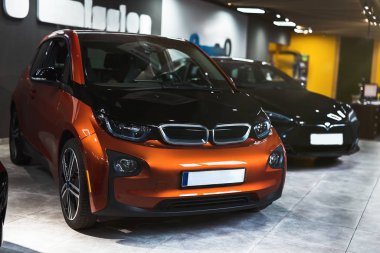 Elektrikli araç satış merkezinde satılık iki araba, çevre dostu konsept.
