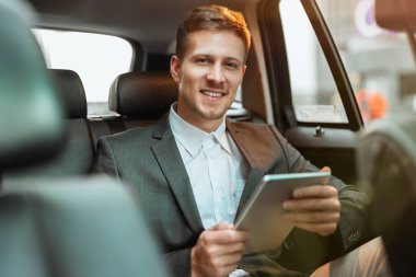 Genç başarılı işadamı borsayı kontrol ediyor, kazanan gibi görünüyor, yatırım ve bankacılık kavramı