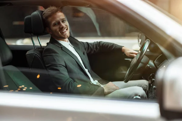 Młody biznesmen jazdy luksusowy samochód wygląda zadowolony, udana koncepcja strategii — Zdjęcie stockowe