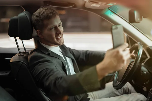 Giovane uomo d'affari sorridente che colpisce una posa durante le riprese selfie nella sua auto sembra felice e soddisfatto, concetto di strategia di business di successo — Foto Stock