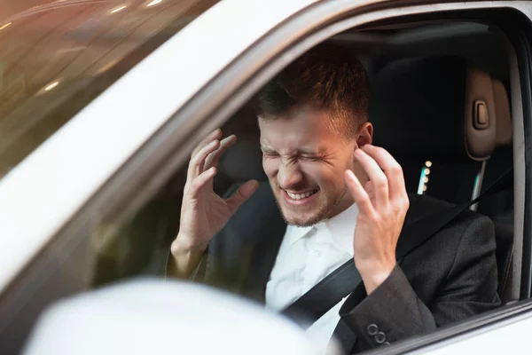 Młody zły biznesmen siedzi w samochodzie wygląda desperacko po ciężkim dniu w miejscu pracy, stresująca koncepcja warunków pracy — Zdjęcie stockowe