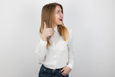 Genç, güzel, gülümseyen sarışın kadın, izole edilmiş beyaz arka planda duran tabela gibi görünüyor, şaşırmış görünüyor, pozitif yaşam tarzı konsepti.