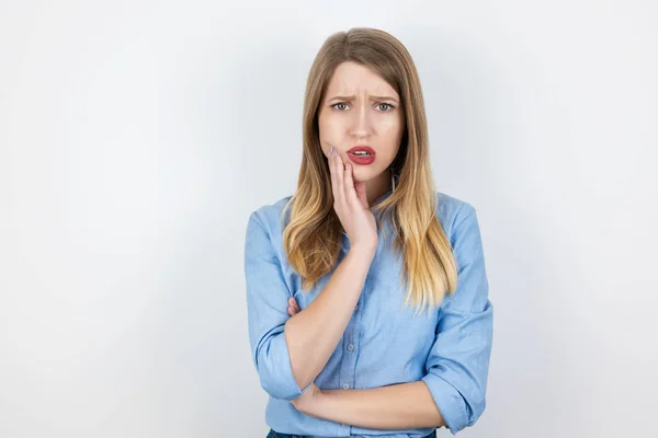 Jong beatuiful blonde vrouw staan op geïsoleerde witte achtergrond lijden aan plotselinge kiespijn, gezondheidszorg en medische concept — Stockfoto