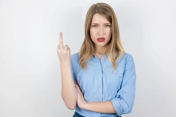 Portrait of young blond brutal woman showing fuck off sign on isolated white background, body language — Stockfoto