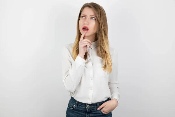 Junge beatuiful blonde Frau sieht nachdenklich stehend auf isoliertem weißen Hintergrund, Körpersprache — Stockfoto