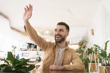 Genç yakışıklı adam, öğle arasında kafede salata yerken ve kahve içerken elini kaldıran garsonu arıyor. kafe ve restoran hizmeti kavramı.