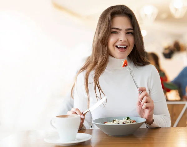 Joven Mujer Hermosa Positiva Sosteniendo Tenedor Con Tomate Mientras Come —  Fotos de Stock