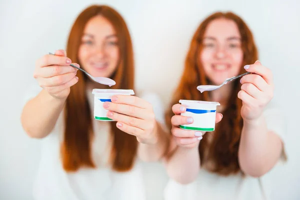 Yoghurt Gehouden Door Twee Roodharige Jonge Vrouwen Geïsoleerde Witte Achtergrond — Stockfoto