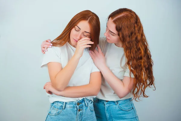 2人の赤毛の若い女性はどちらも孤立した白い背景の上に立っています1つは彼女の動揺泣いている友人 友情とサポートの概念をコンソール — ストック写真