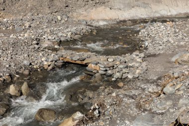 Dağın eteklerindeki yaya köprüsünde bir taş var.