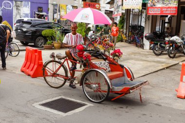 Georgetown Caddesi üzerinde müşteri bekleyen çekçek sürücüsü