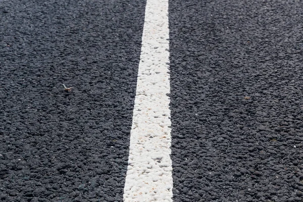 Línea blanca y sólida. Marcado de carreteras en una carretera asfaltada — Foto de Stock