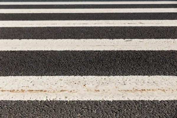 Pedestrian road crossing, white marking on an asphalt road.