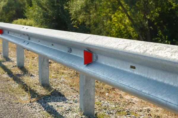 red road reflectors along the road. metal road fencing. Road and traffic safety