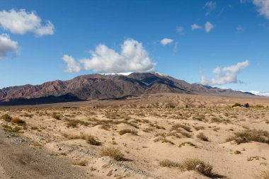 Kırgızistan 'daki Issyk-Kul Gölü bölgesindeki dağların tepesindeki beyaz bulutlar.
