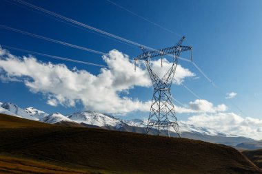 Kırgızistan 'da yüksek voltajlı elektrik hattı. Dağlarda elektrik direği.