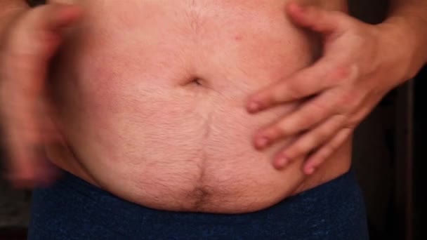A man shows his fat on his stomach and pats his stomach. — Stock Footage Man Shows His Fat His Stomach Pats His Stomach Royalty Free Stock Video