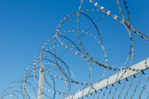 забор с колючей проволокой, колючей проволокой против голубого неба
.