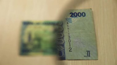 Masada elinde büyüteçle duran 2000 Ugandalı şiline bakın. İş ve finans kavramı. ters taraf
