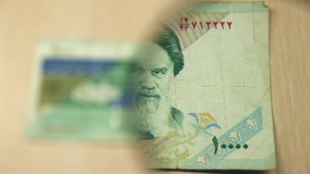 看一张1万伊朗里亚尔的钞票躺在桌子上 桌子上放着放大镜 商业和金融的概念 — 图库视频影像