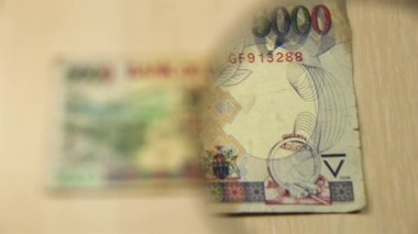 Masada 5 bin Ugandalı şilinin büyüteçle durduğunu görün. İş ve finans kavramı. Obverse