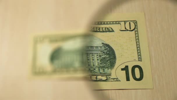 看一张10美元的钞票放在桌子上 桌上有放大镜 商业和金融的概念 — 图库视频影像