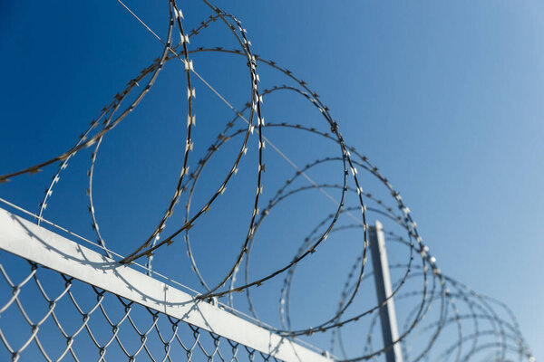 забор с колючей проволокой, колючей проволокой против голубого неба
.