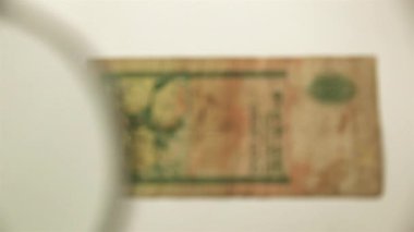 On Sri Lanka Rupisi ve büyüteç. Bir kağıt faturayı büyüteçten izle. ters.