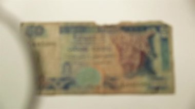 50 Sri Lanka Rupisi ve büyüteç. Bir kağıt faturayı büyüteçten izle. Obverse.