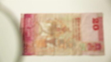 20 Sri Lanka Rupisi ve büyüteç. Bir kağıt faturayı büyüteçten izle. ters.