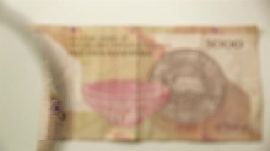 Beş bin İran ritüeli ve bir büyüteç. Bir kağıt faturayı büyüteçten izle. ters.