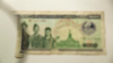 Bin Lao Kip ve bir büyüteç. Bir kağıt faturayı büyüteçten izle. Obverse.