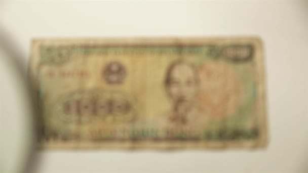 1000人のベトナム人のドンと虫眼鏡 拡大鏡で紙幣を見る 全世界 — ストック動画