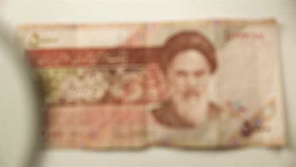 五千伊朗里亚尔和一个放大镜通过放大镜查看一张纸钞 — 图库视频影像