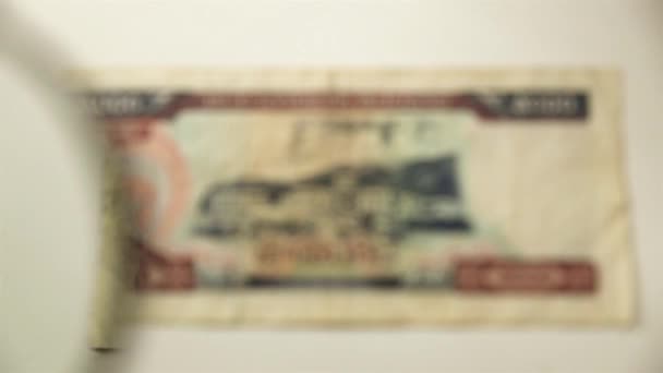5000老挝基普和放大镜 通过放大镜查看一张纸钞 — 图库视频影像