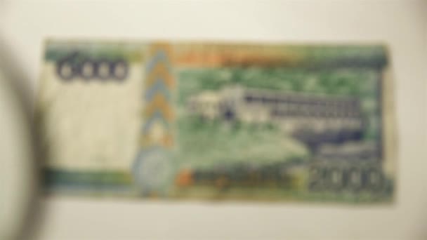 两千老挝基普和一个放大镜通过放大镜查看一张纸钞 — 图库视频影像