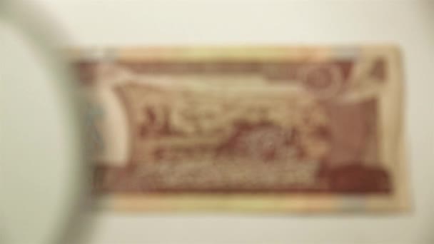 エチオピアの10本のバーと虫眼鏡 拡大鏡で紙幣を見る — ストック動画