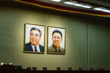 Pyongyang, Kuzey Kore - 29 Temmuz 2014: Kim Il Sung ve Kim Jong Il 'in portreleri Pyongyang' daki Grand People 's Study House' un konferans salonunda duvarda asılı..