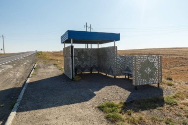 Kazakistan bozkırında otobüs durağı. Yolda otobüs bekleyecek bir yer..