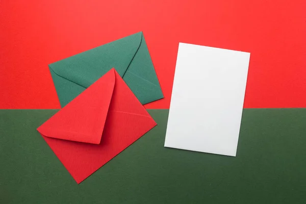 Envelopes vermelhos e verdes no fundo de férias de Natal. Depósito plano . — Fotografia de Stock