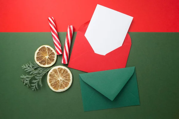 Envelopes vermelhos e verdes no fundo de férias de Natal. Depósito plano . — Fotografia de Stock