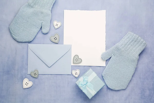 Маленькие детские перчатки, блокнот и эвлоп на голубом фоне. Плоский лежал. Вид сверху — стоковое фото