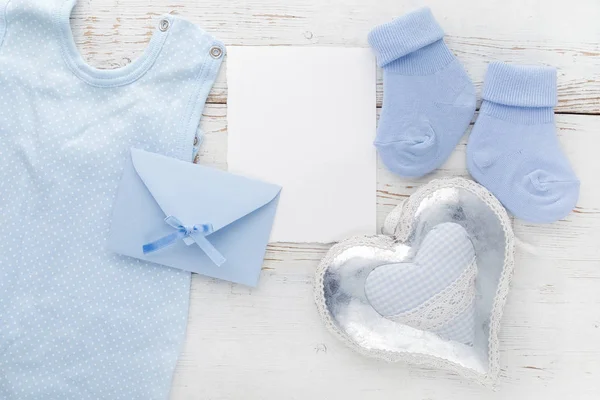 Small boy blue socks, blank card, evelop and heart on white wooden background. Flat lay. — Stock Photo, Image